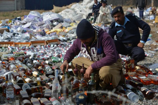 Pakistani customs officials arrange bottles of liquor before destroying them at a ceremony in Islamabad onJanuary 26, 2014. Pakistani custom officials destroyed narcotics and other contraband items from different parts of the country to mark the occasion of International Customs Day. AFP PHOTO/Farooq NAEEM