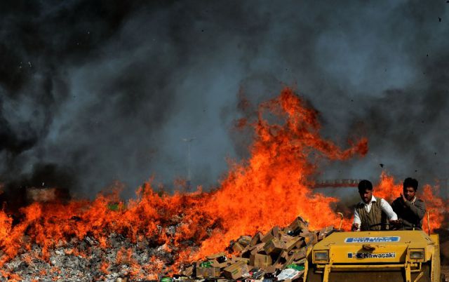 Pakistani customs officials use a steamroller to crush bottles of liquor at a ceremony in Lahore on January 26, 2014. Pakistani custom officials destroyed narcotics and other contraband items from different parts of the country to mark the occasion of International Customs Day. AFP PHOTO/Arif ALI