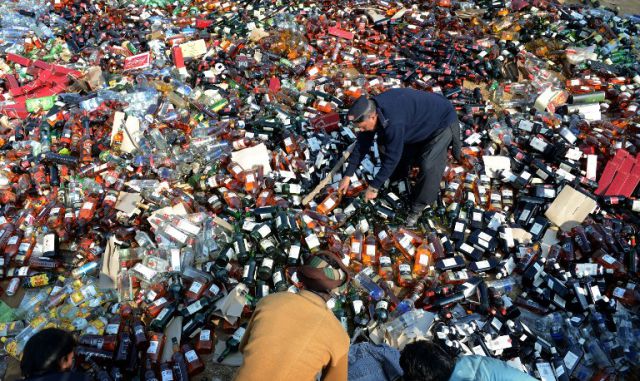 Pakistani customs officials arrange bottles of liquor before destroying them at a ceremony in Lahore on January 26, 2014. Pakistani custom officials destroyed narcotics and other contraband items from different parts of the country to mark the occasion of International Customs Day. AFP PHOTO/Arif ALI