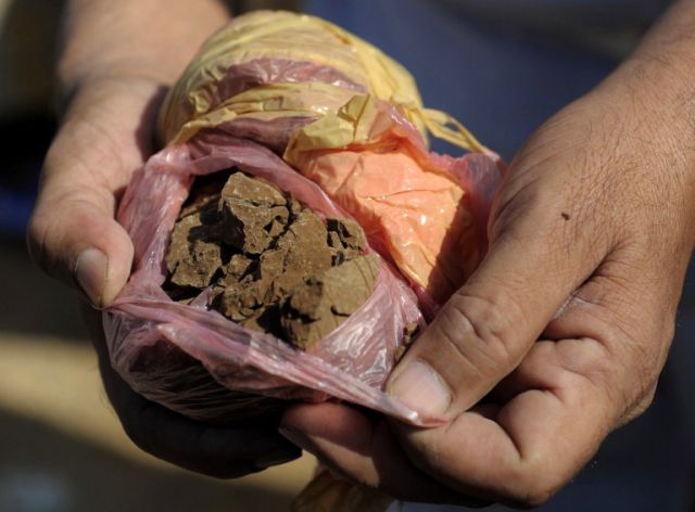 Pakistani custom officials destroy a package of seized heroin at a ceremony in Karachi on January 26, 2014. Pakistani custom officials destroyed narcotics and other contraband items from different parts of the country to mark the occasion of International Customs Day. AFP PHOTO/Rizwan TABASSUM