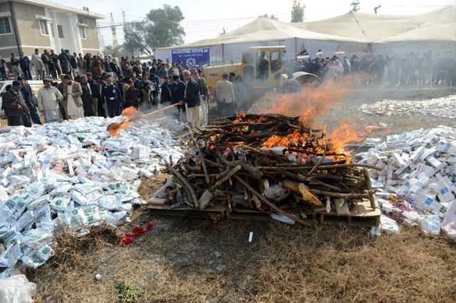 Pakistani customs officials set fire to narcotics and other contraband items at a ceremony in Islamabad on January 26, 2014. Pakistani custom officials destroyed narcotics and other contraband items from different parts of the country to mark the occasion of International Customs Day. AFP PHOTO/Farooq NAEEM