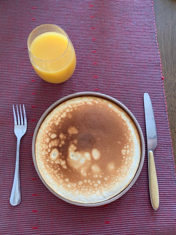 Palacinka pokrývajúca takmer celý tanier na prestretom stole