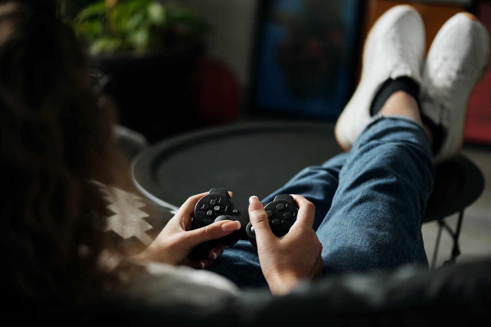 Person in Blue Denim Jeans Holding Black Game Controller
