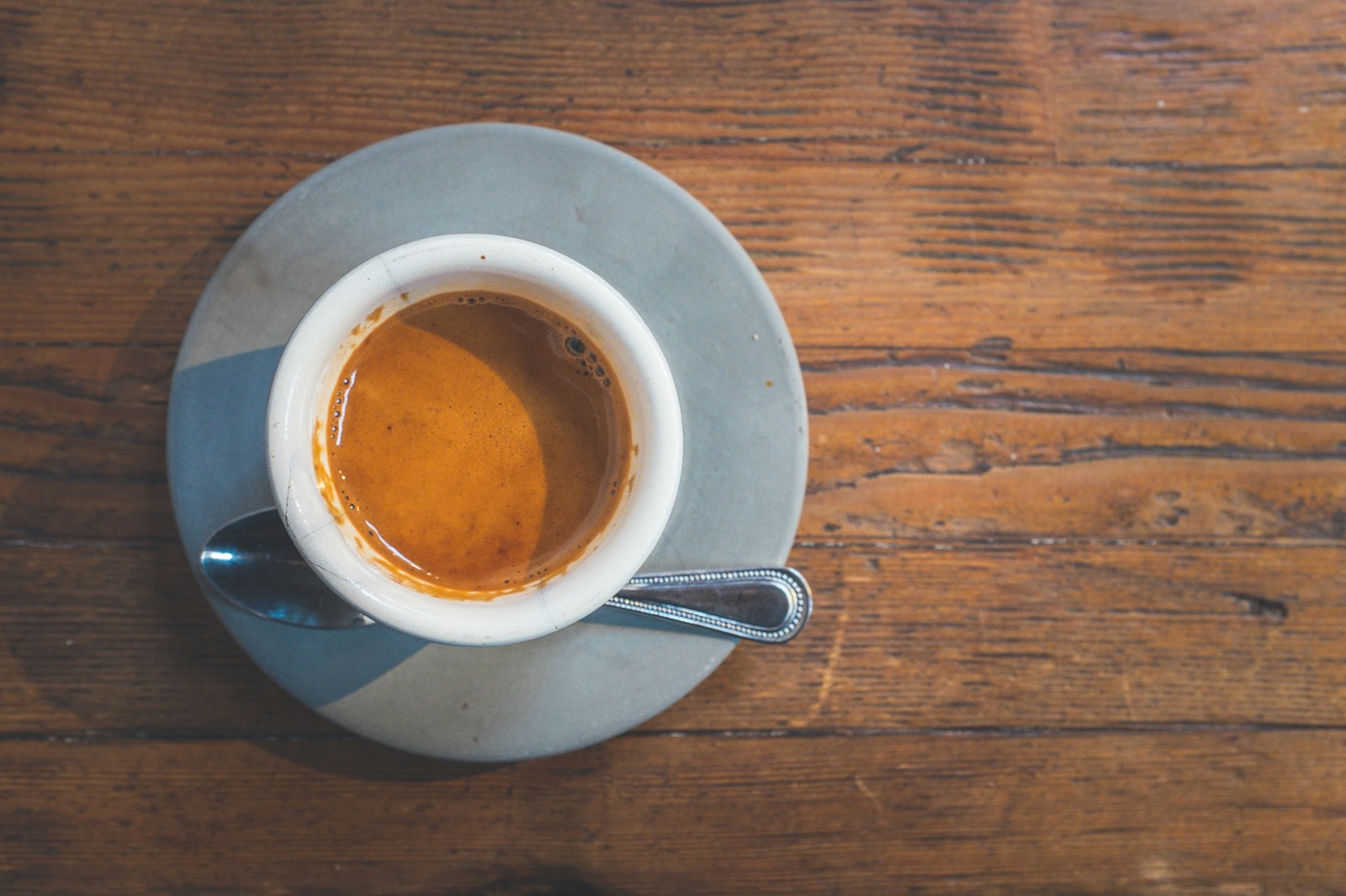filled white cup on top of gray saucer