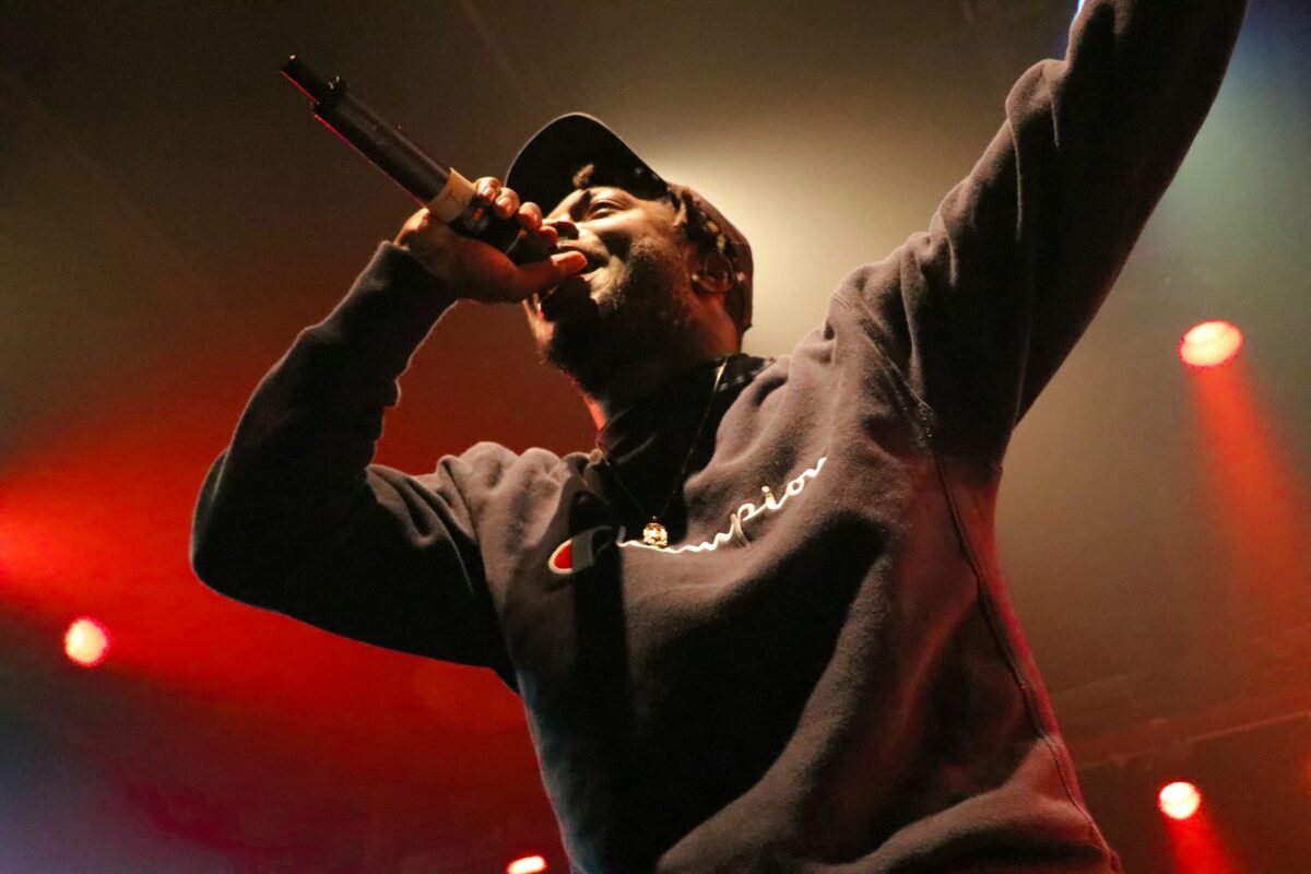 black person holding microphone and singing on stage