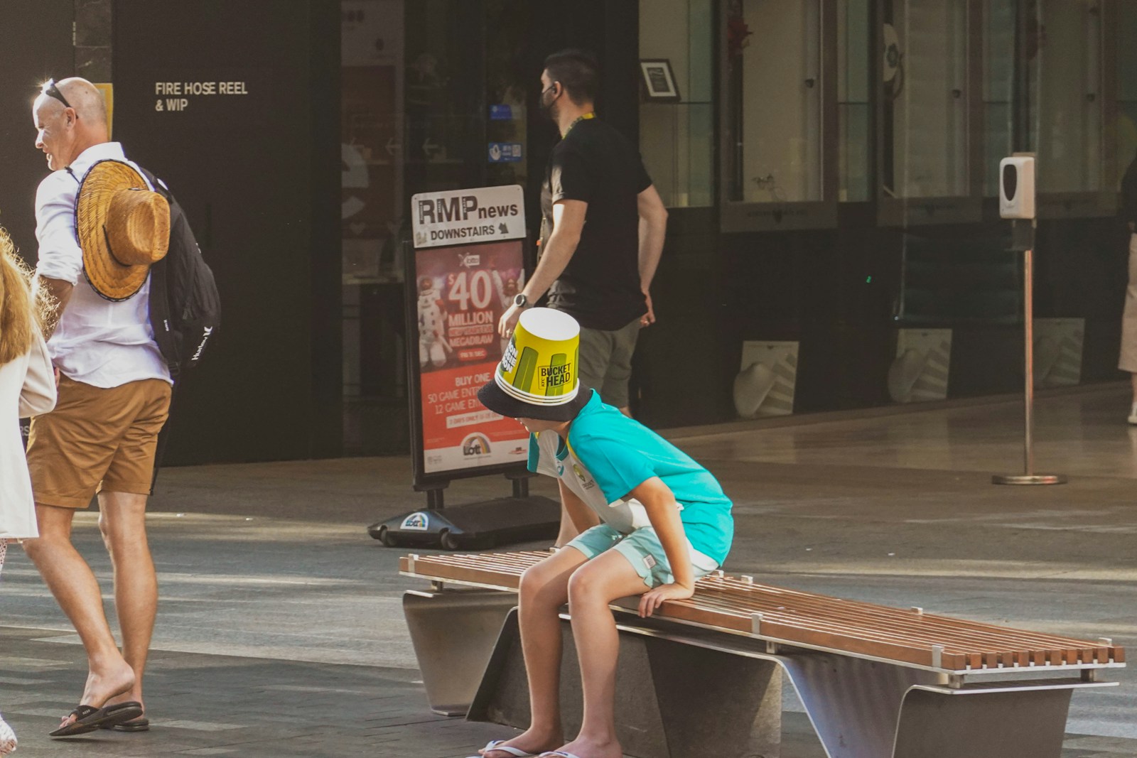 a young boy sitting on top of a wooden bench
