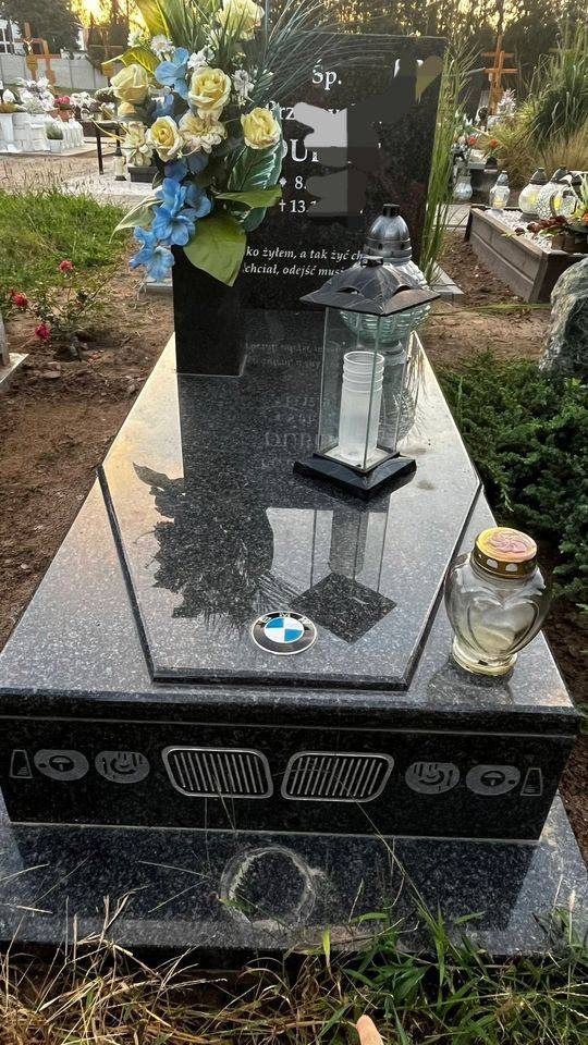 Kamenný pomník s logom BMW a vyobrazením prednej masky auta
