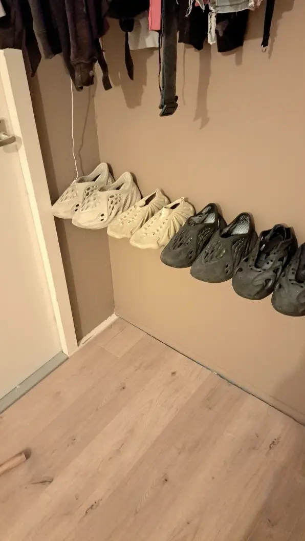 Úzka polička splýva s pozadím a ponechá v obraze len rad obuvi.