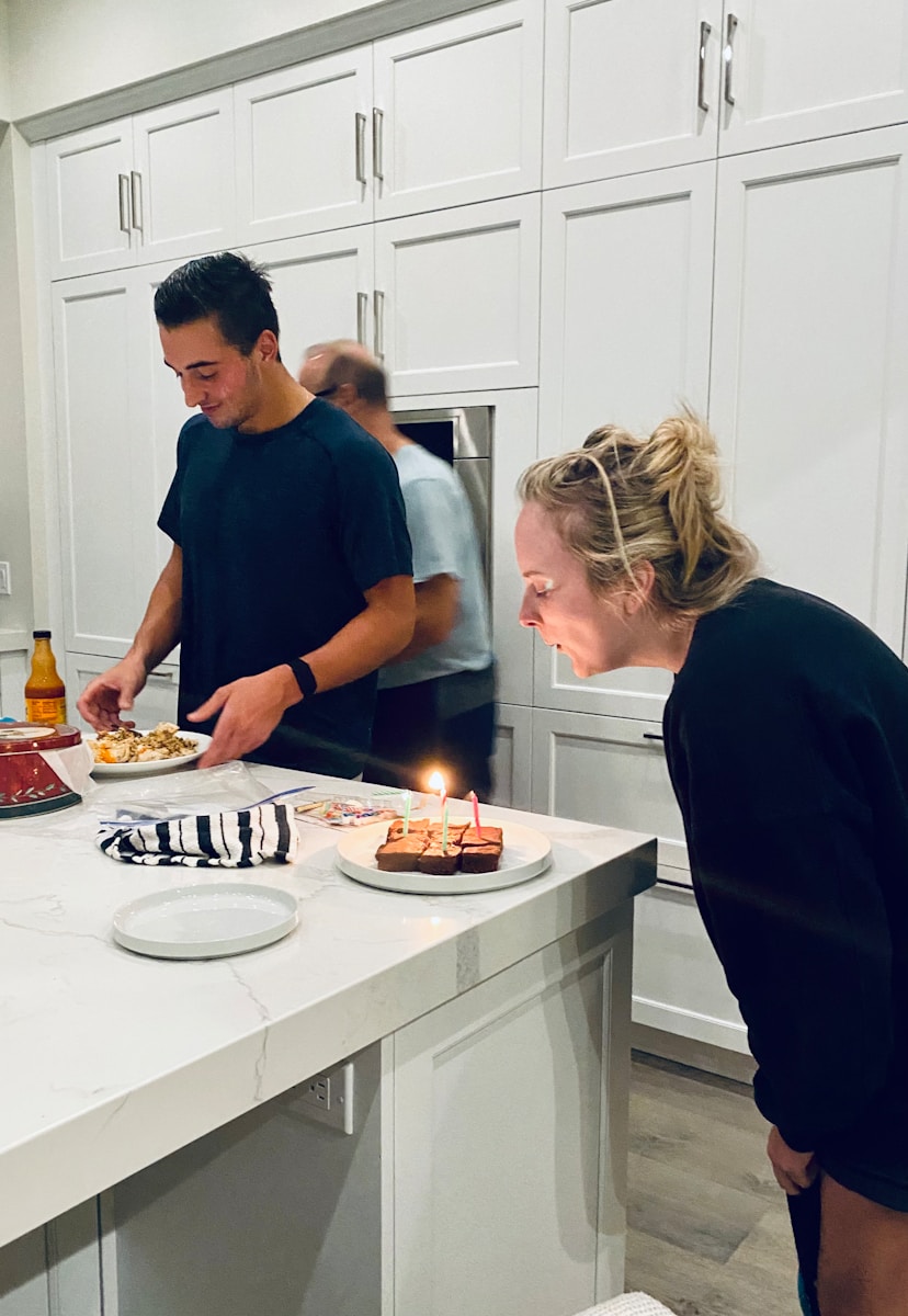 man in blue crew neck t-shirt holding white ceramic plate with cake