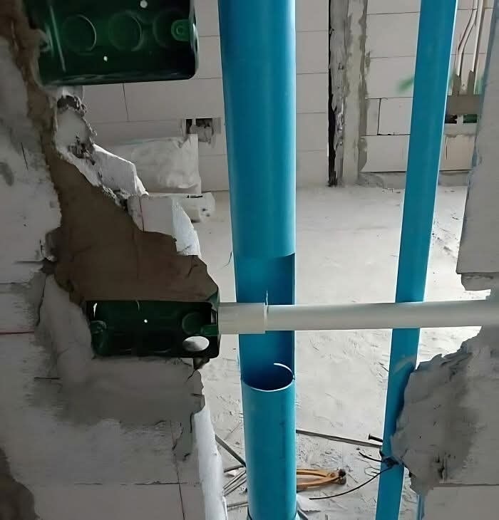 Viaceré rúrky sa stretávajú v úzkom priestore rozostavanej steny.