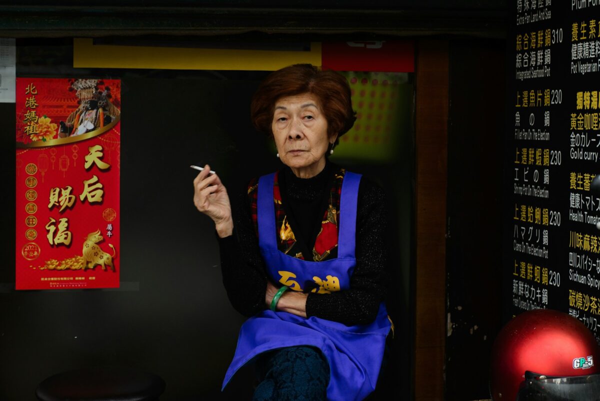 a woman sitting down smoking a cigarette