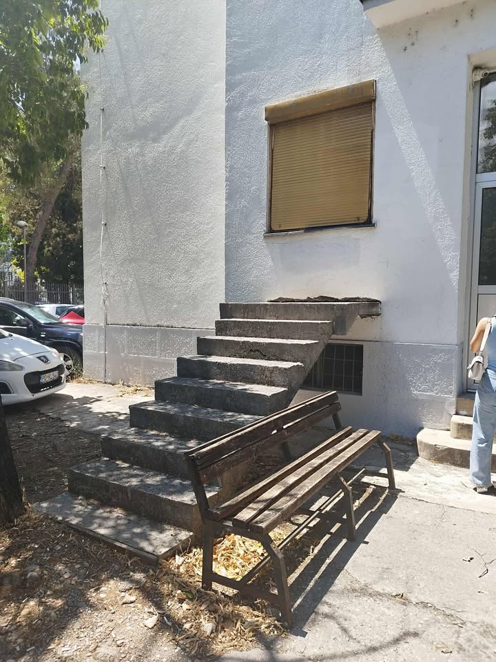 Vonkajšie kamenné schody vedúce pod zatvorené okno na fasáde