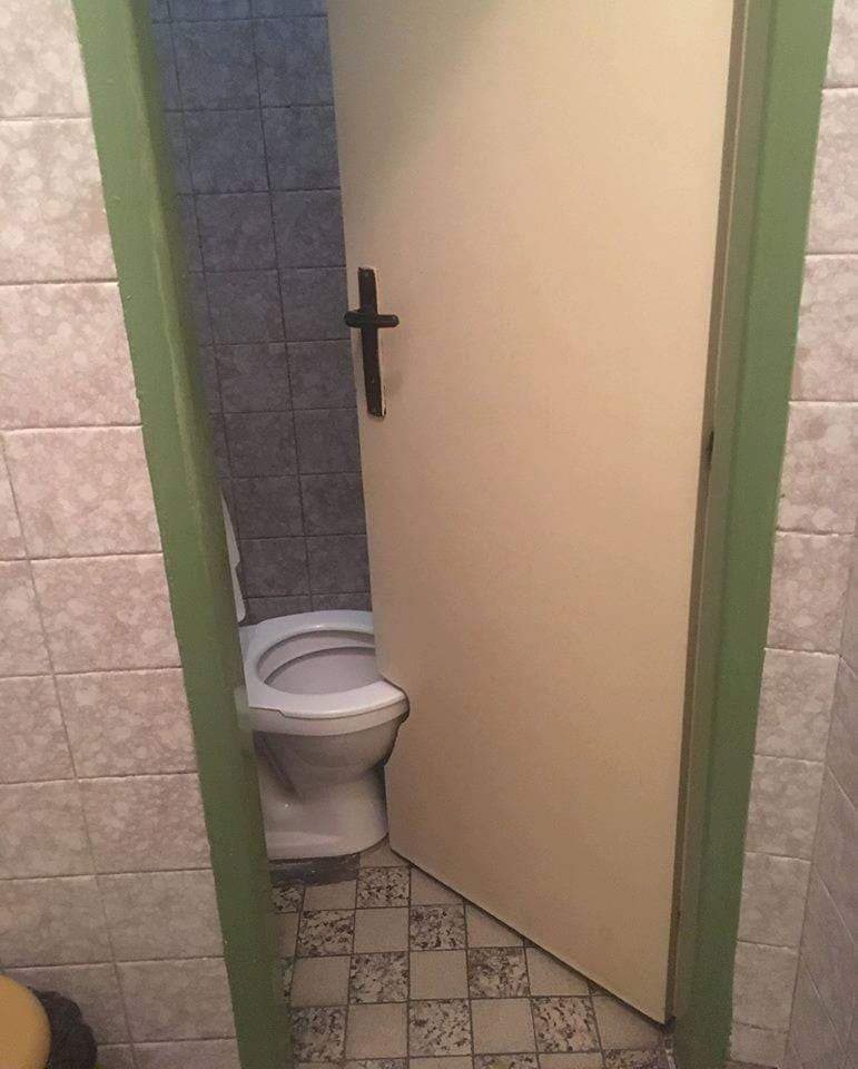 Dvere s vyrezaným spodným okrajom vedľa toalety
