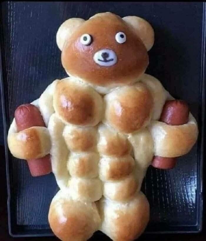Pečivo v tvare medveďa so svalnatým trupom a činkami v rukách.