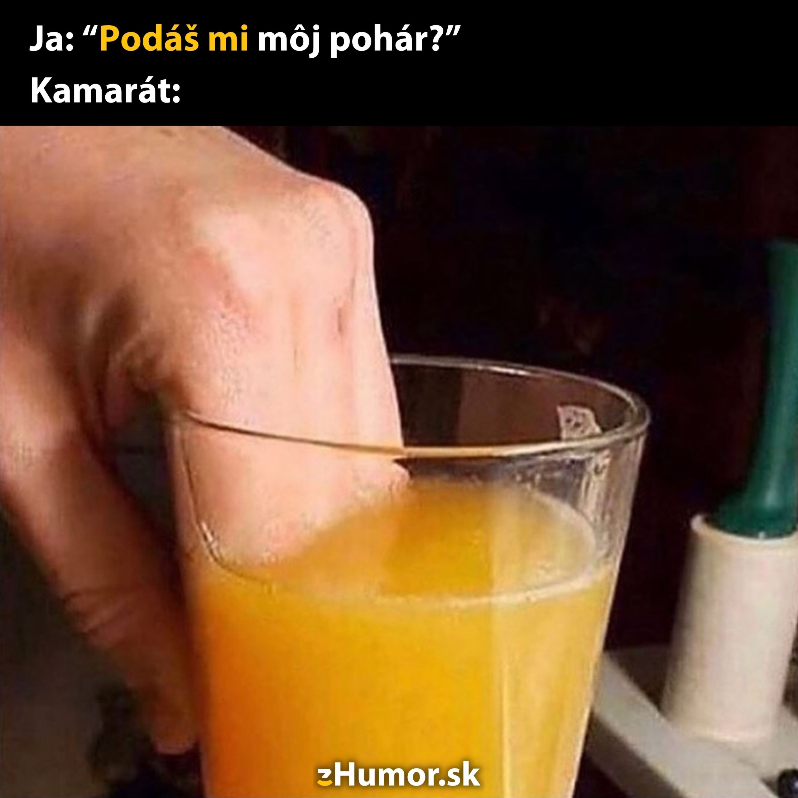 Ruka podávajúca pohár s pomarančovým džúsom originálnym spôsobom.
