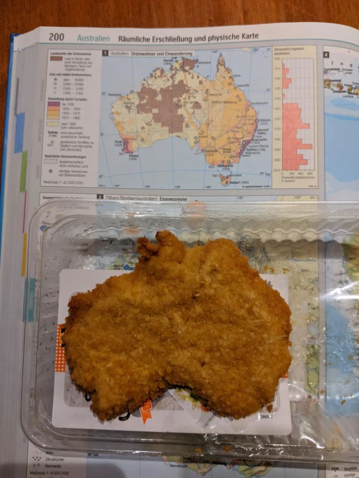 Vyprážaný rezeň v tvare Austrálie položený na mape sveta.