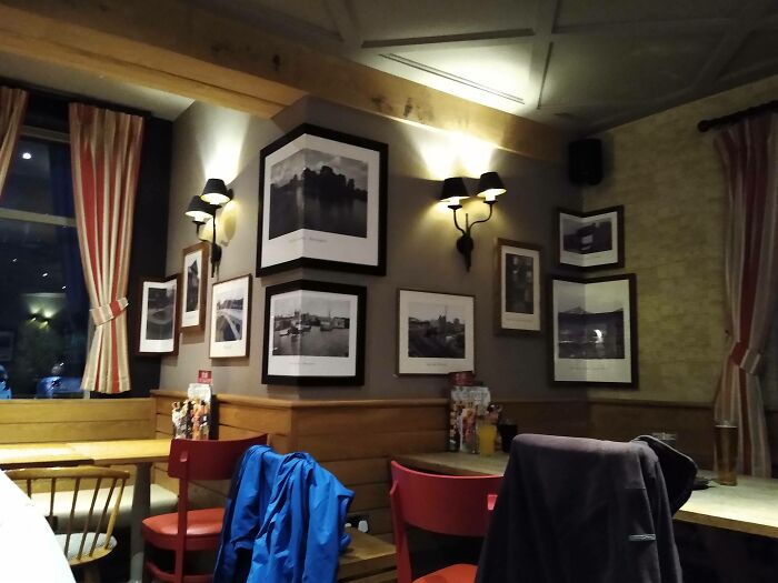 Reštauračný interiér s umeleckými fotografiami na stenách a útulnou atmosférou na večernej návšteve.