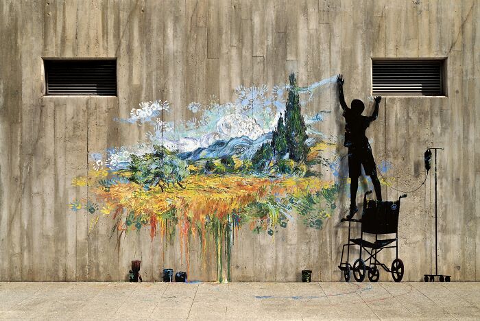 Mural: Silueta dieťaťa na invalidnom vozíku maľujúca farebnú krajinu na betónovú stenu.
