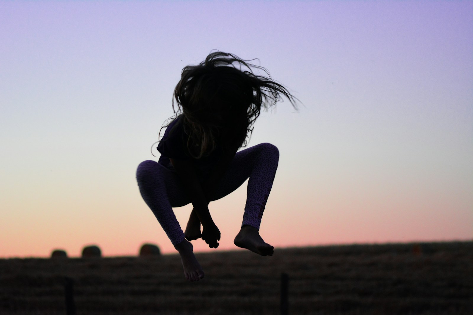 a silhouette of a person jumping in the air