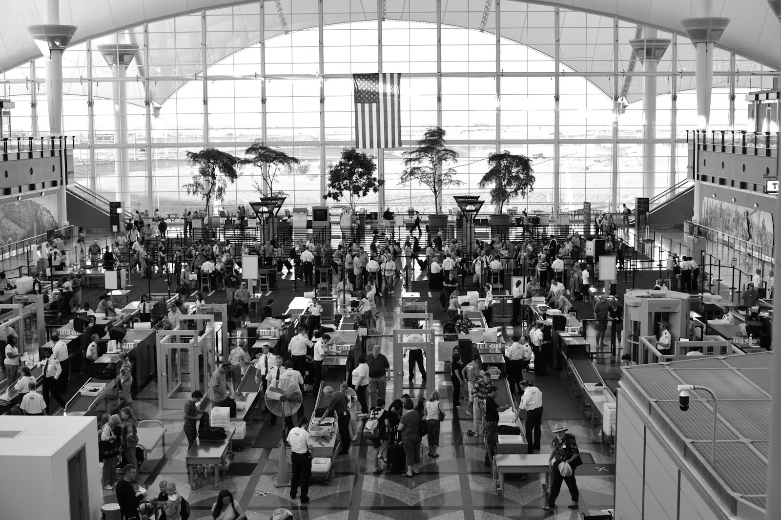 a black and white photo of people in an airport