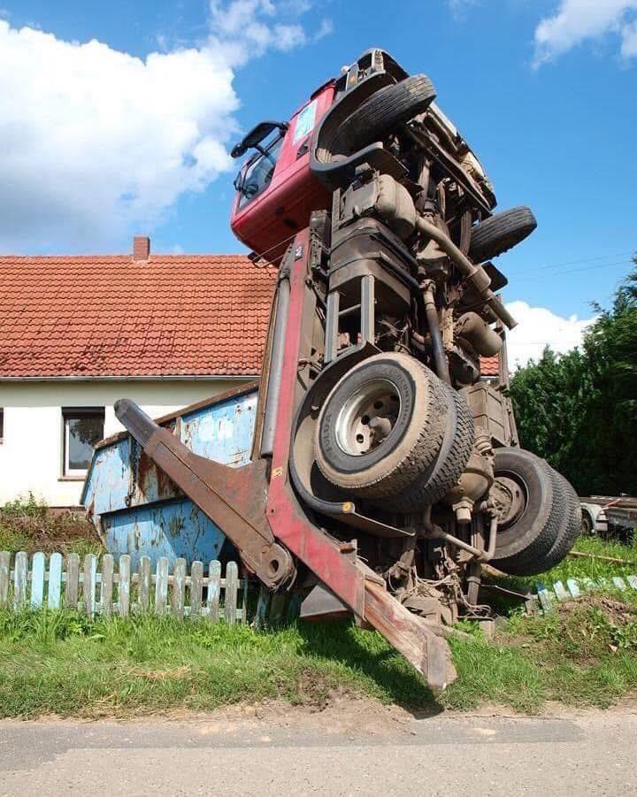 Nákladné vozidlo vo zvislej polohe pri plote.
