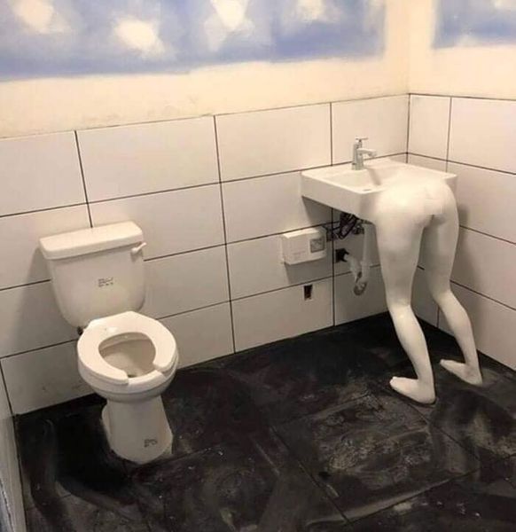 Neobvyklé umývadlo s nohami v kúpeľni, vedľa klasického WC, vytvára zábavnú inštaláciu.
