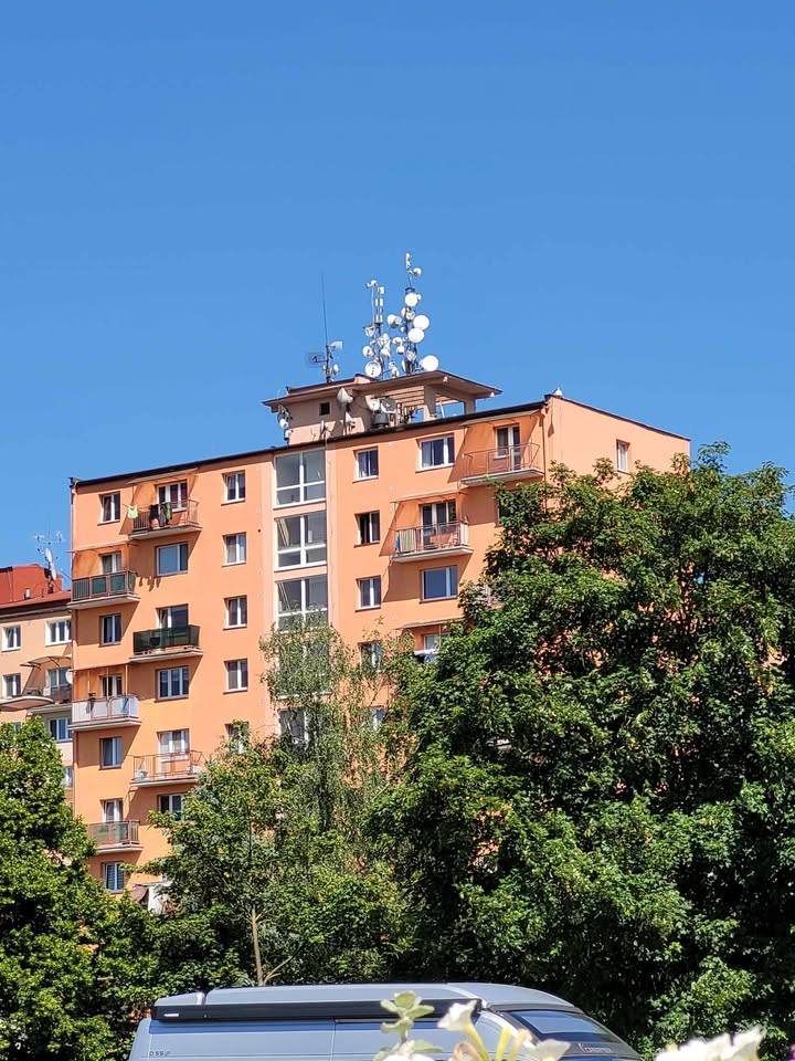 Obytná budova s množstvom antén a zariadení na streche.