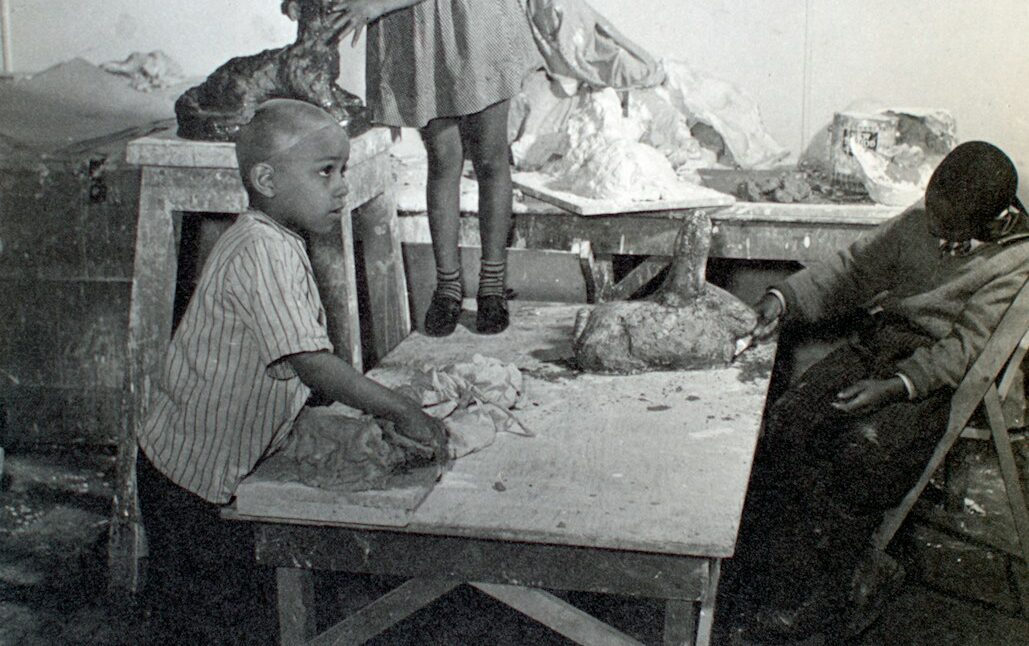 grayscale photo of 3 child on wooden table