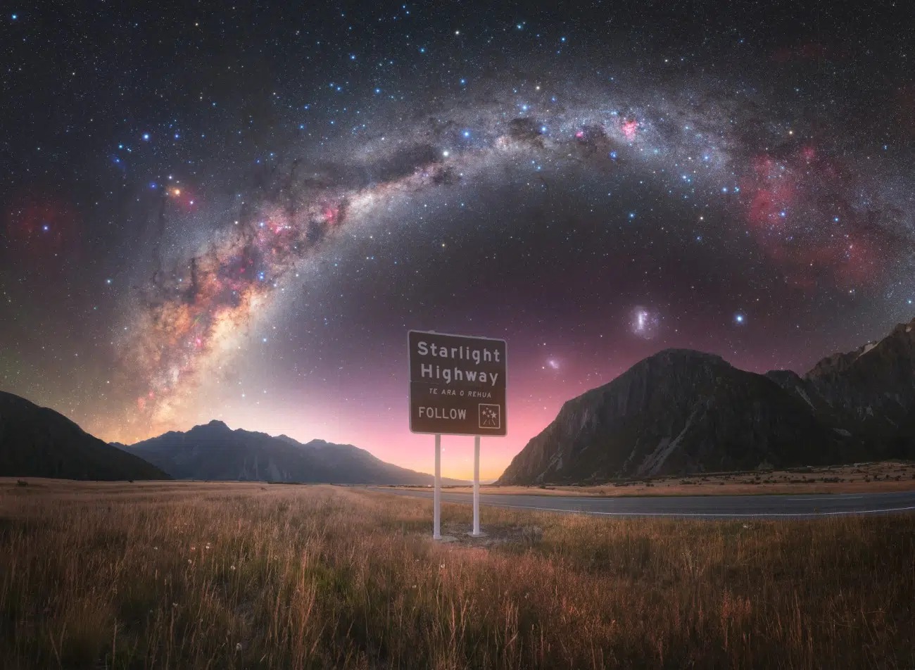 Cesta pod hviezdnou oblohou s mliečnou dráhou v popredí, značka Starlight Highway.