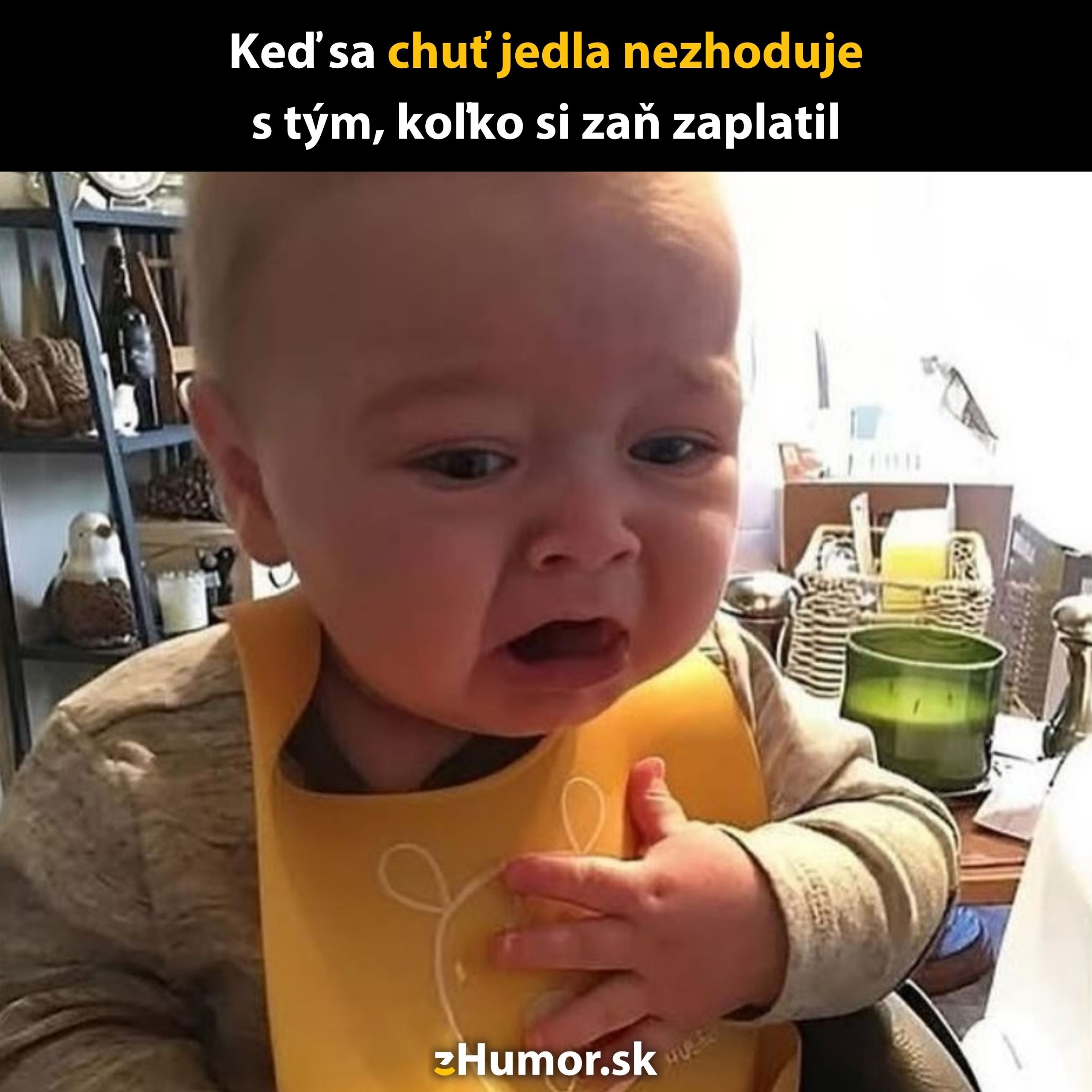 Dieťa s prekvapeným výrazom pri stole, okolo sú kuchynské predmety a dekorácie.