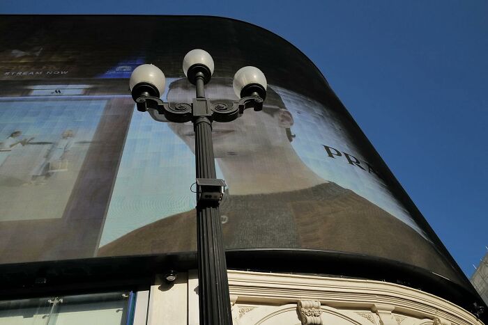 Billboard s lampou v mestskom prostredí pod modrou oblohou.