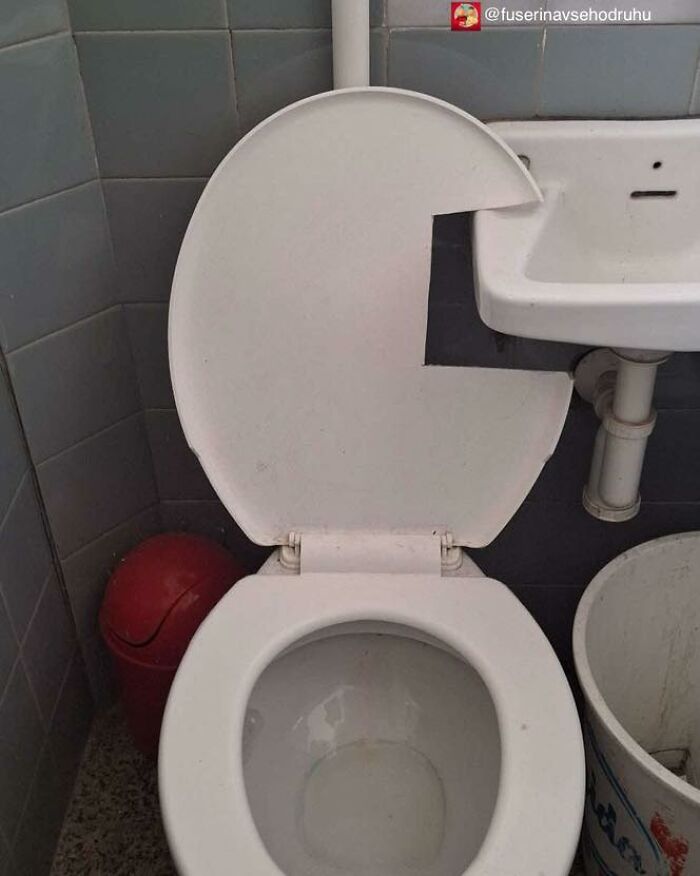 Toaleta s vekom zlomeným do tvaru Pac-Mana, vedľa umývadla a červeného koša.