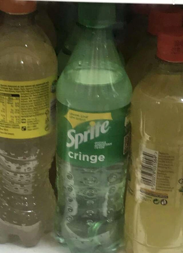 Fľaša nealkoholického nápoja Sprite s názvom cringe vystavená na polici medzi ostatnými fľašami.