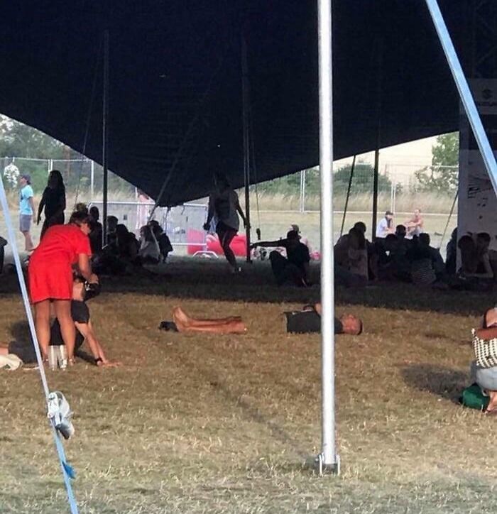Ľudia oddychujú pod veľkým stanom na festivalovom podujatí.