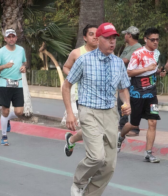 Skupina bežcov na vonkajšom maratóne, múž s červenou šiltovkou a nanukom v popredí.