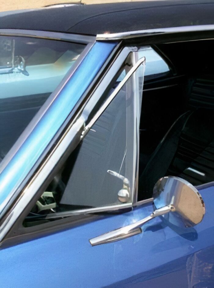 Modré retro auto s bočným zrkadlom a zvláštnym oknom, detail karosérie a sklo.