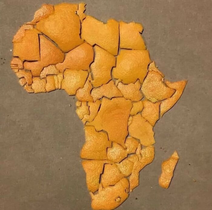 Mapa Afriky z pomarančovej šupky na šedej podložke. Kreatívny príklad zložitej mozaiky.