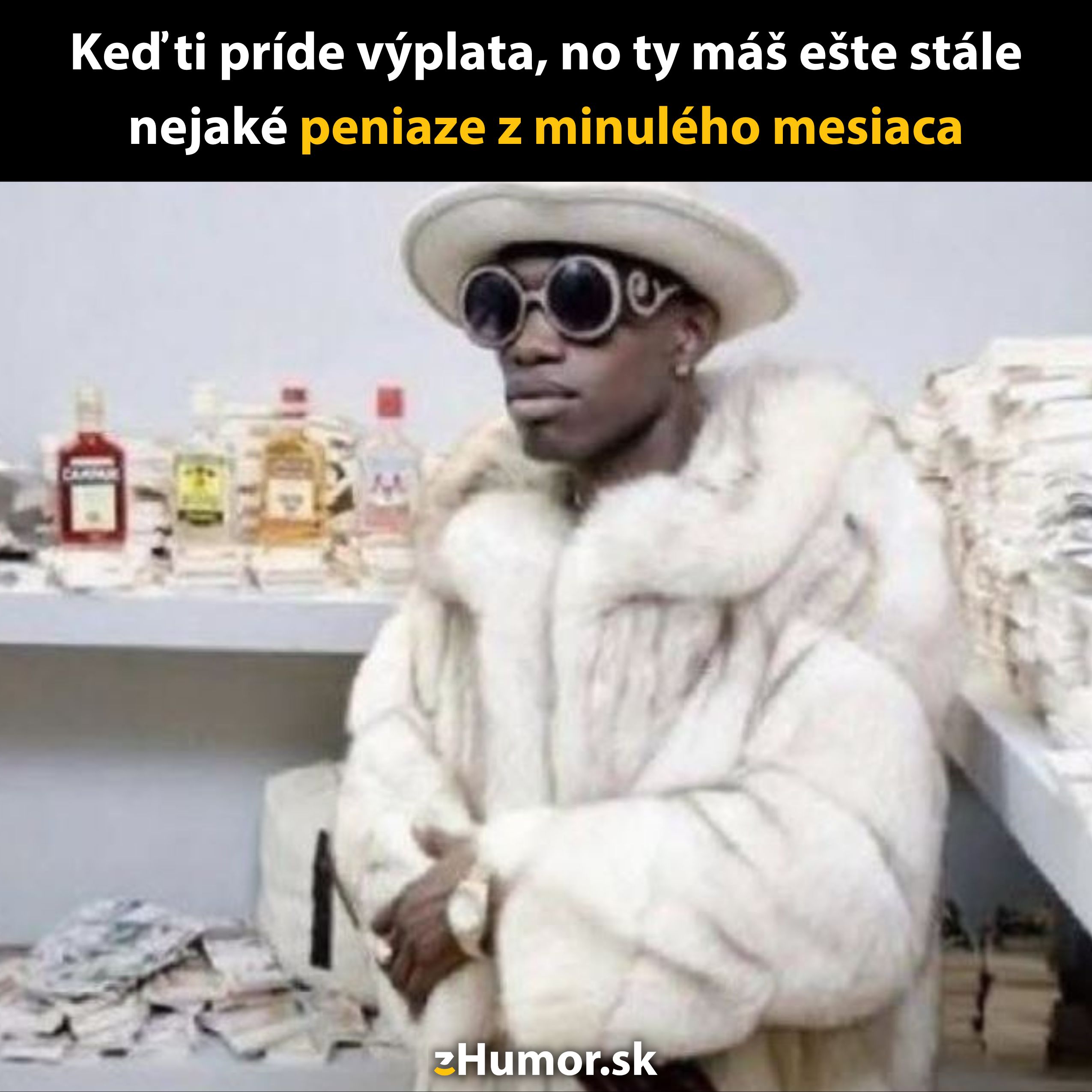 Muž v kožuchu s okuliarmi stojí pri stole s alkoholom a peniazmi, vyjadruje pocit bohatstva a výplaty.