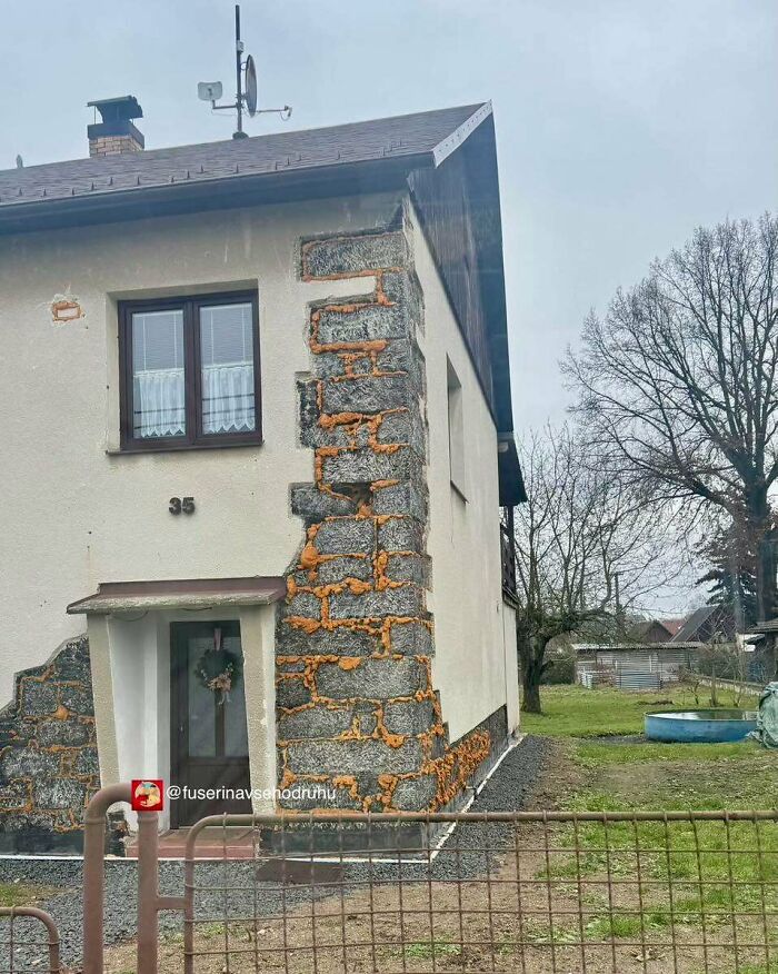 Starší rodinný dom so zvláštnym fasádnym riešením na vidieku.