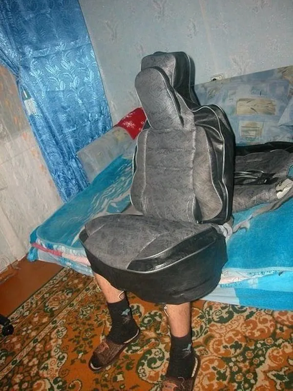 Osoba sediaca na posteli s oblečeným poťahom sedadla z auta ako kostým.