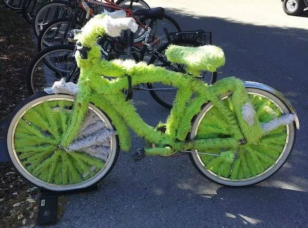 Jasnozelený bicykel s chlpatým poťahom zaparkovaný na ulici vedľa ďalších bicyklov.