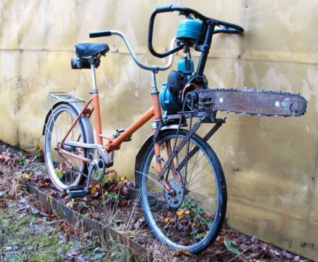Bicykel s reťazovou pílou na riadidlách pri stene, jedinečný spôsob, ako spojiť dopravu a rezanie dreva.