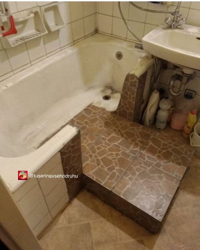Kúpeľňa s vaňou a umývadlom, obložené dlažbou, čistiace prostriedky uložené pod umývadlom.