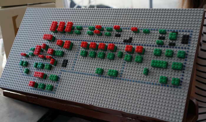 Lego model ukazujúci schematický plán s farebnými kockami na bielej podložke, pravdepodobne znázorňujúci sieťové zapojenie.