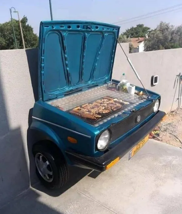 Auto polovička prerobená na gril s otvorenou kapotou. Kreatívny nápad na BBQ v starom aute.