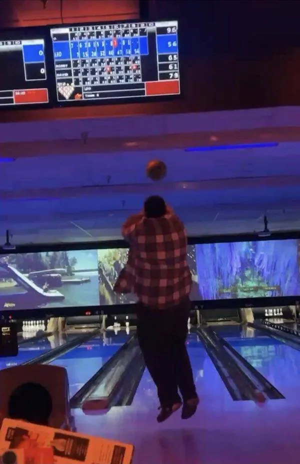 Bowlingová dráha s hráčom, ktorý hádže guľu vysoko do vzduchu, zobrazená tabuľka skóre.
