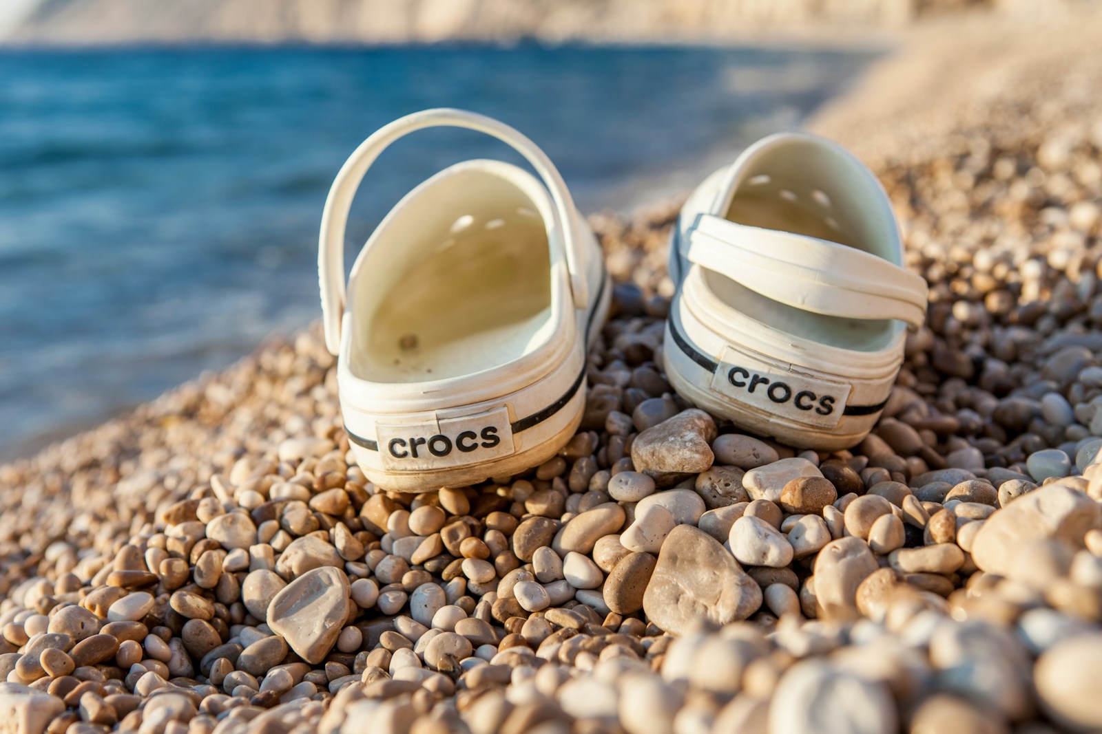 a pair of shoes sitting on top of a rocky beach