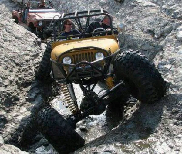 Off-road jeep prekonáva skalnatý terén s veľkými pneumatikami, adrenalínové dobrodružstvo v prírode.