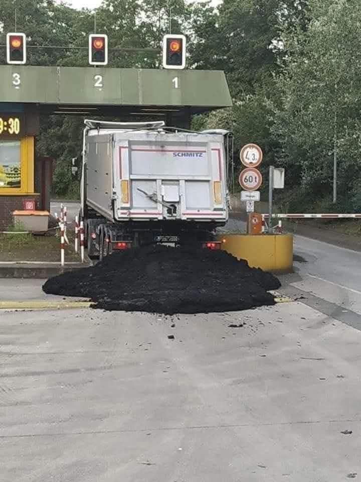 Kamión uviazol pod mostom, vysypal náklad na ceste, ktorá je zablokovaná dopravnými značkami.