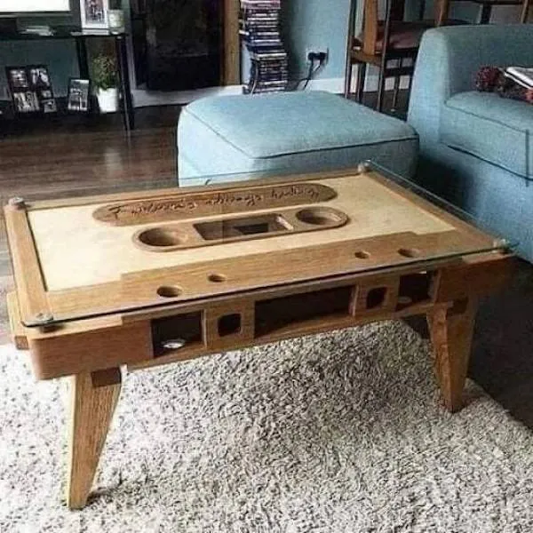 Stolík v tvare retro kazety v modernom obývacom priestore, kombinácia dreva a skla.